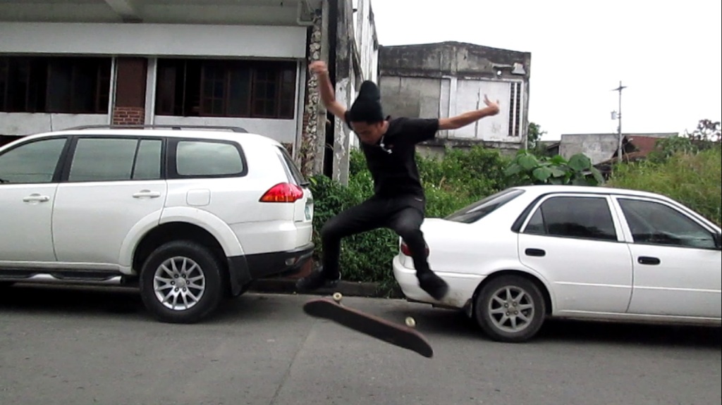 JI doing a kickflip on a skateboard